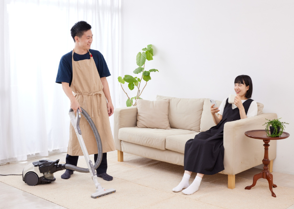 家事をする男性と休む女性